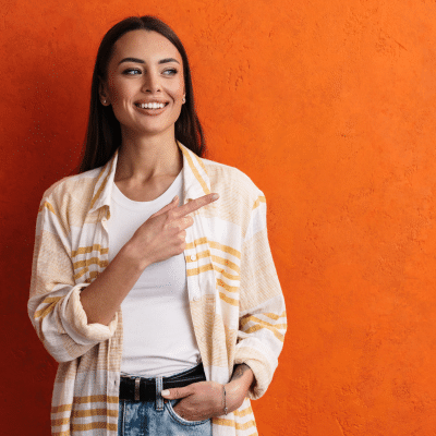 Woman in yellow flannel, smiling and pointing, representing cryosurgery in Virginia Beach